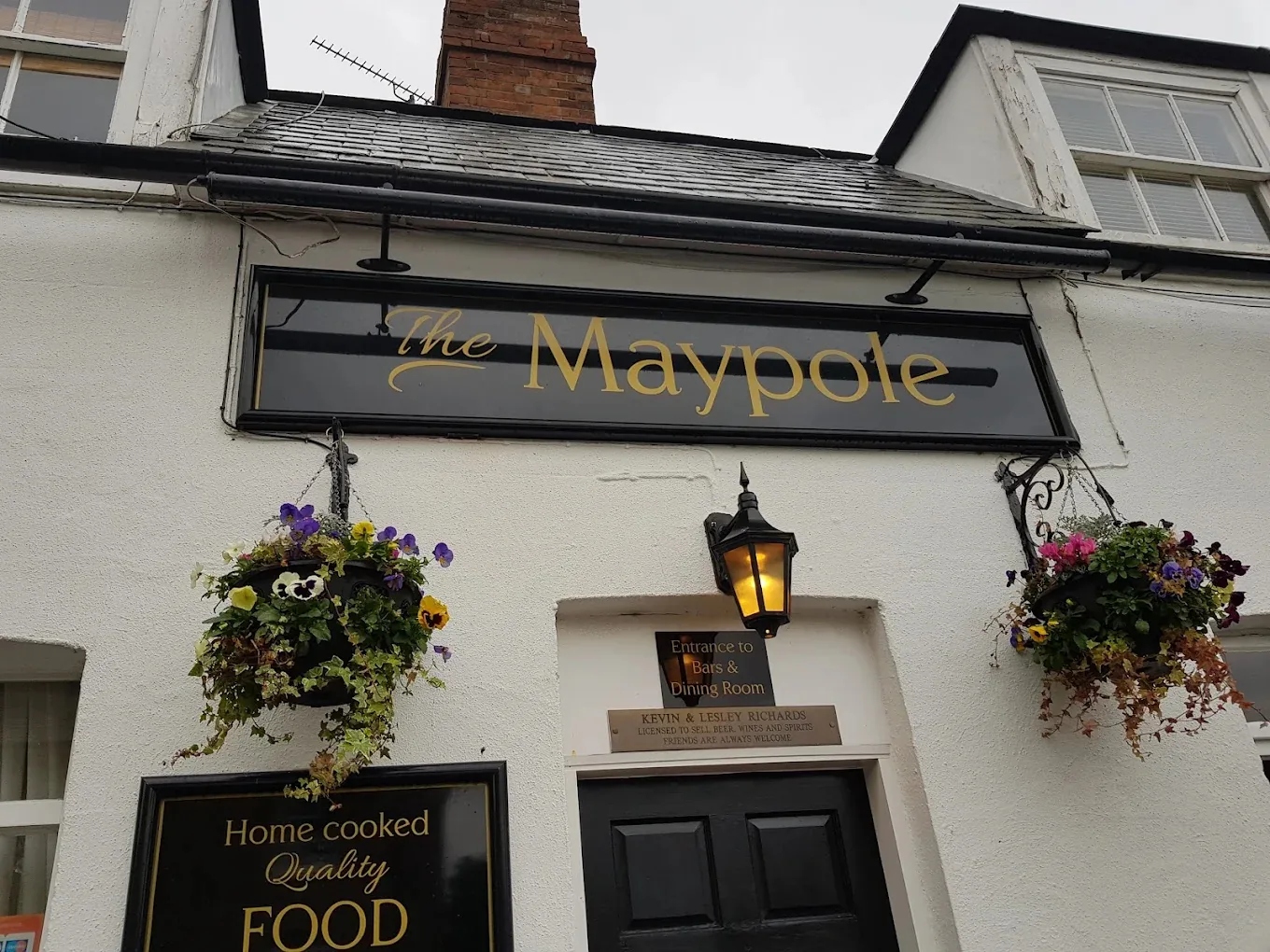 The Maypole sign and hanging baskets above the door